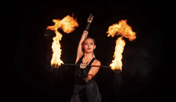 Kobieta podrzucająca zapalony kij do fireshow